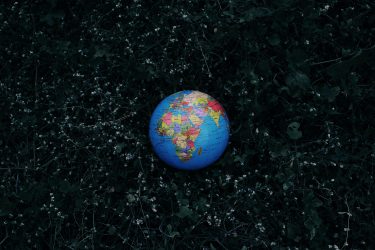 A globe showing Europe and Africa laid out on dark grass to illustrate whether trade policy can be sustainable sustainable