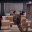 A screenshot from episode 6 of season one of the series "And Just Like That..." featuring the characters Carrie Bradshaw and Charlotte York in Carrie's warehouse, surrounded by carboard boxes