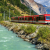 Travelling by train (pictured running alongside a lake) can make for the perfect sustainable summer holiday.
