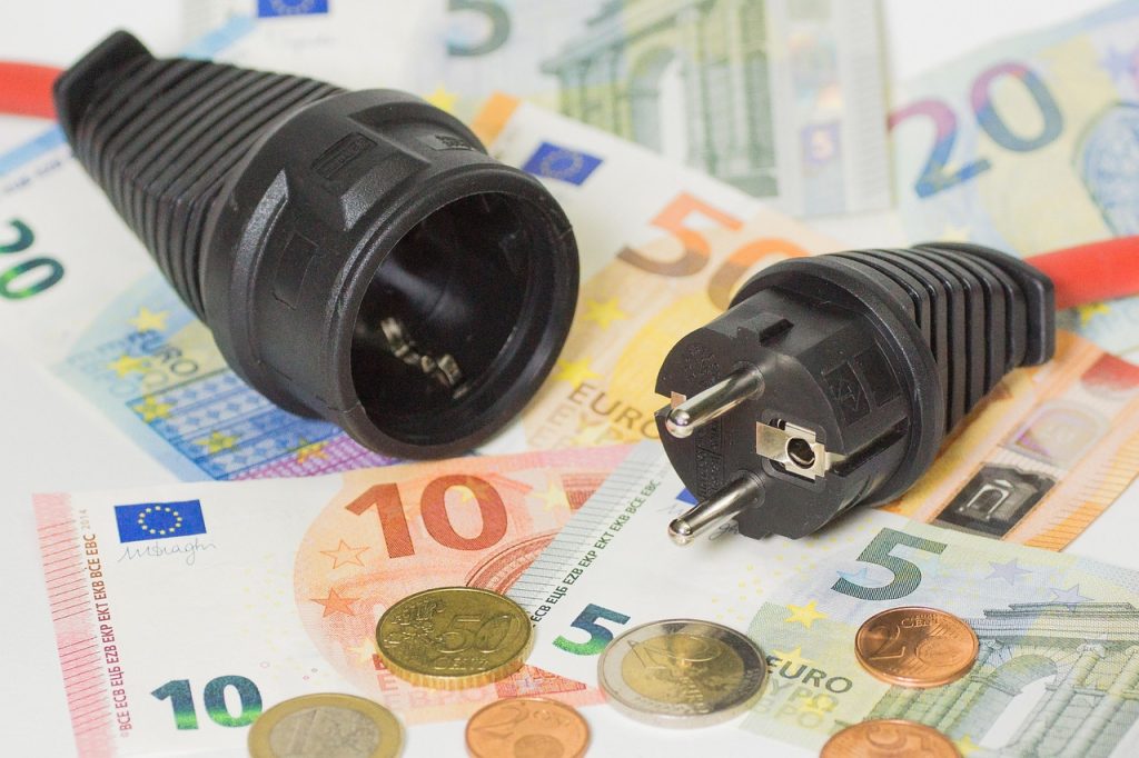 Photo of a plug and money. Choosing the right energy contract